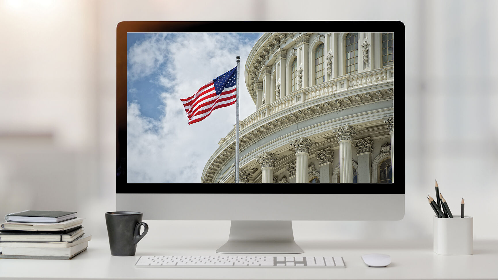 Close up view of office room with computer, office supplies and coffee cup on white desk with blurred background